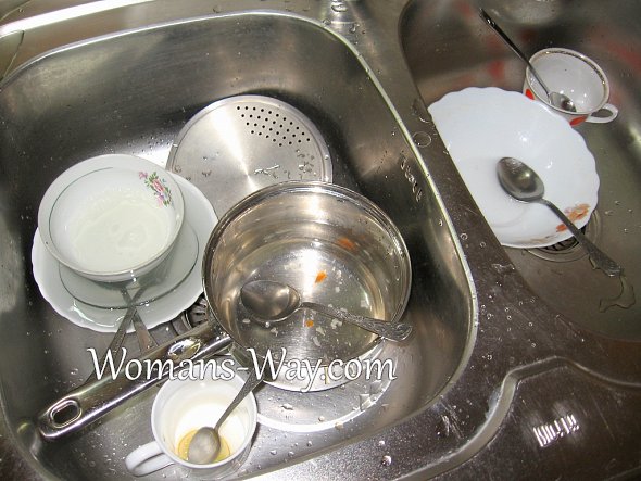 Посуда в мойке залитая водой и моющим средством