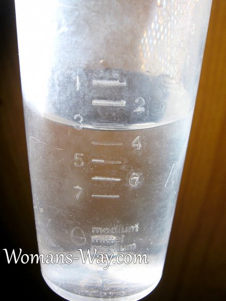 Вода в мерном стакане электрической яйцеварки
