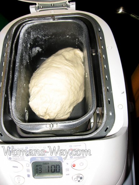 Замешанное тесто для пельменей или вареников во внутренней емкости хлебопечки